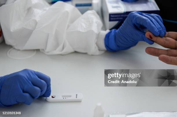 Health worker wearing a protective medical equipment extracts blood from a patient to make an antibody test for COVID-19 at the Dworska Hospital in...