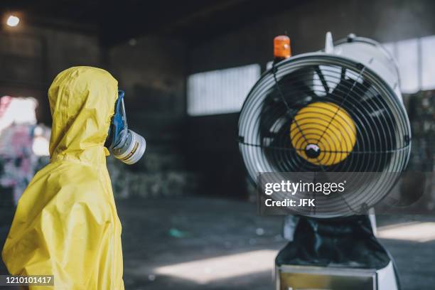 In this file photo taken on April 10, 2020 an employee wearing protective equipment stands next to a snow cannon during a press conference on "Unique...