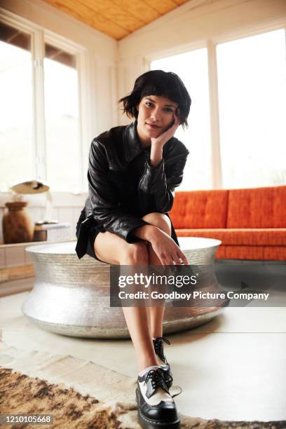 stylish young woman sitting on a table at home - leather skirt stock pictures, royalty-free photos & images