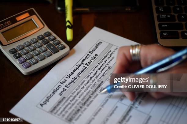 In this photo illustration, a person files an application for unemployment benefits on April 16 in Arlington, Virginia. The government reported...
