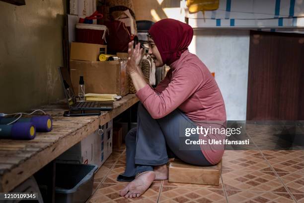 Yoga instructor, Dewi Amsari, teaching an online class from her home, as the government closed tourist destinations, schools, offices and urging...