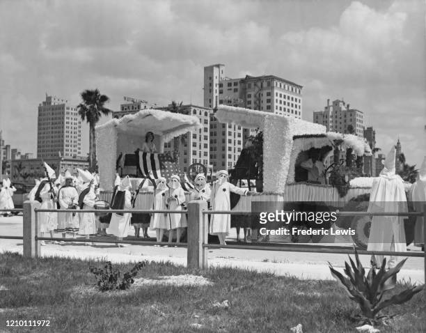 Group of Ku Klux Klan women next to a parade float, Miami, circa 1940.