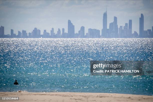 Lone swimmer is seen at Coolangatta Beach with Surfers Paradise in the background, on the Queensland - New South Wales border in Brisbane on April...