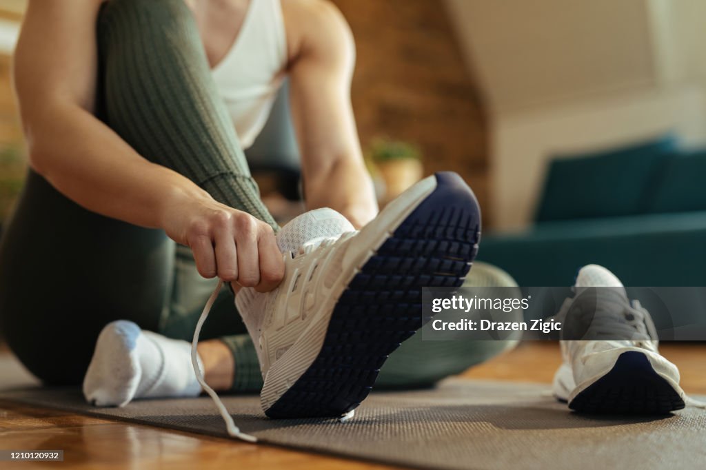 Close-up of athletic woman putting on sneakers.
