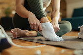 Close-up of athletic woman putting on socks.
