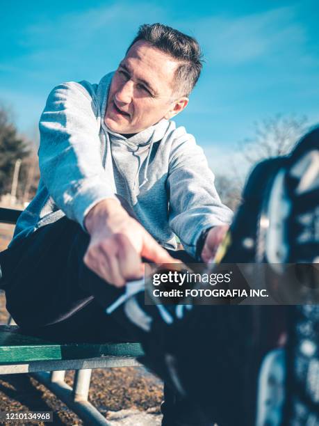 father getting ready to play hockey outdoors - family ice skate stock pictures, royalty-free photos & images