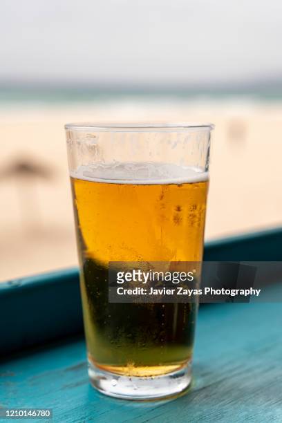 beer glass on table by beach - sea cup stock pictures, royalty-free photos & images