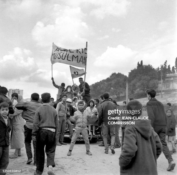 Young Algerians wave a banner proclaiming "Muslim Algeria" and an FLN flag on December 11, 1960 in Algiers as violent pro-FLN and pro-independence...