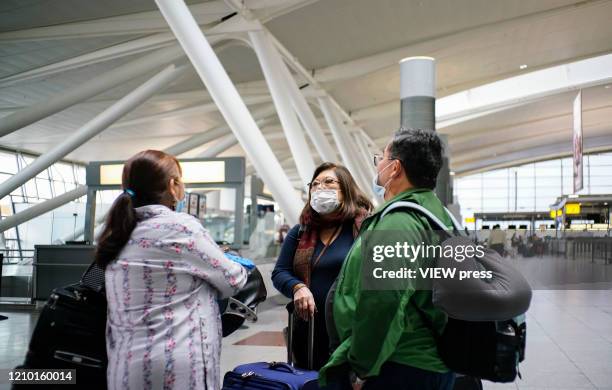 People wear face masks inside the John F. Kennedy International Airport in New York on March 03, 2020. New York confirms second coronavirus case, as...