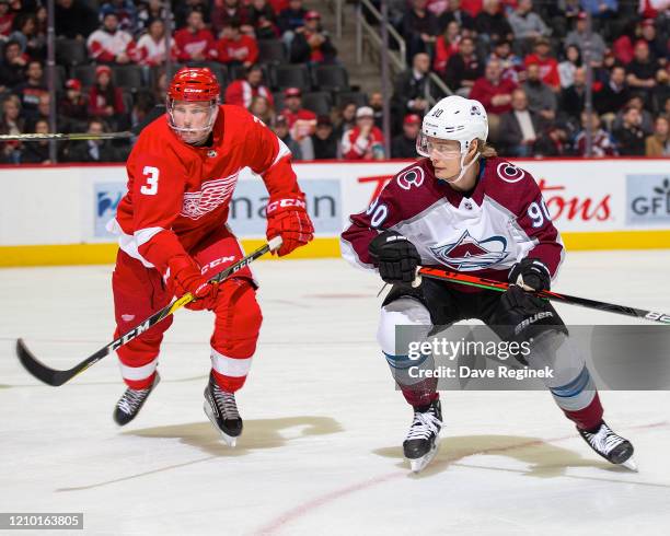 Alex Biega of the Detroit Red Wings defends against Vladislav Namestnikov of the Colorado Avalanche during an NHL game at Little Caesars Arena on...