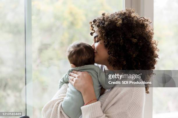 mama verbringt zeit mit baby junge - black mother holding newborn stock-fotos und bilder