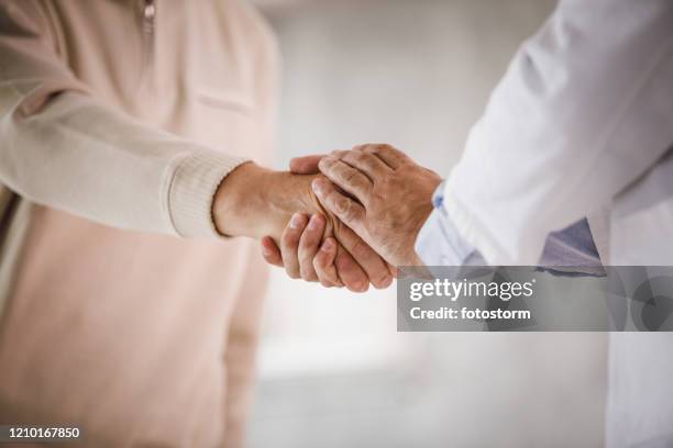 doctor and patient handshake - parkinsons disease stock pictures, royalty-free photos & images