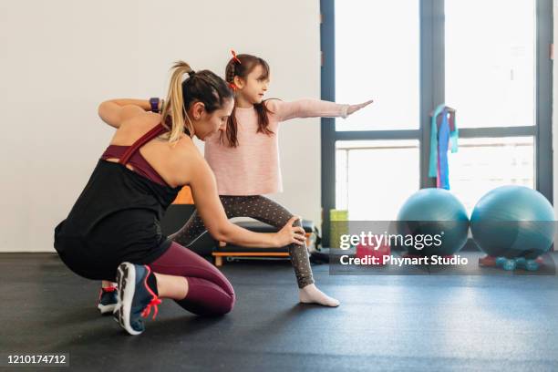 mid adult mother practicing yoga with her daughter ,beautiful mother and daughter training yoga workout - kid gymnastics stock pictures, royalty-free photos & images