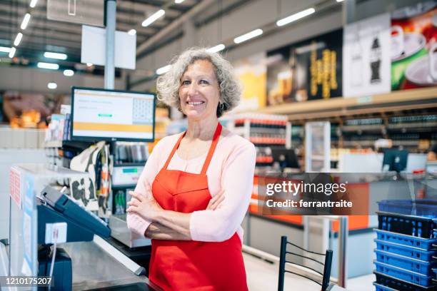 hogere vrouw die als kassier in supermarkt werkt - part time job stockfoto's en -beelden