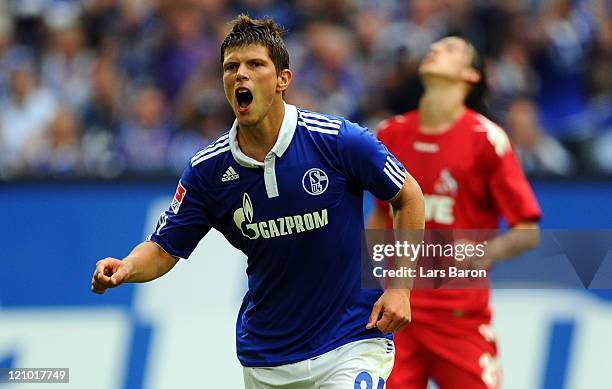 Klaas Jan Huntelaar of Schalke celebrates next to Pedro Geromel of Koeln after scoring his teams first goal during the Bundesliga match between FC...