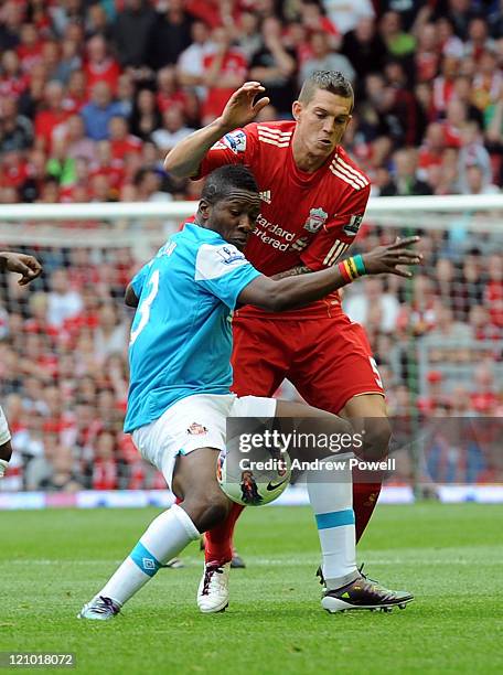 Asamoah Gyan of Sunderland and Daniel Agger of Liverpool in action during the Barclays Premier League match between Liverpool and Sunderland at...