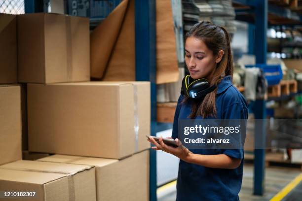 warehouse worker updating the stock on mobile app - storage room boxes stock pictures, royalty-free photos & images