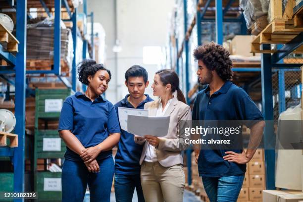 female manager discussing delivery schedules with staff - employee stock pictures, royalty-free photos & images