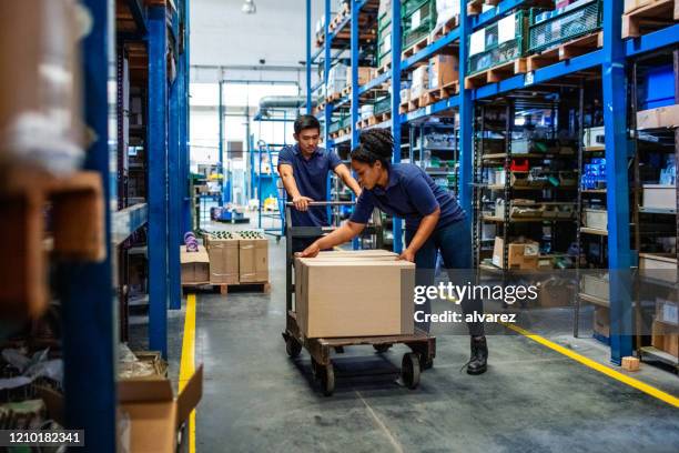 工場で箱を移動する流通倉庫労働者 - ワゴン ストックフォトと画像