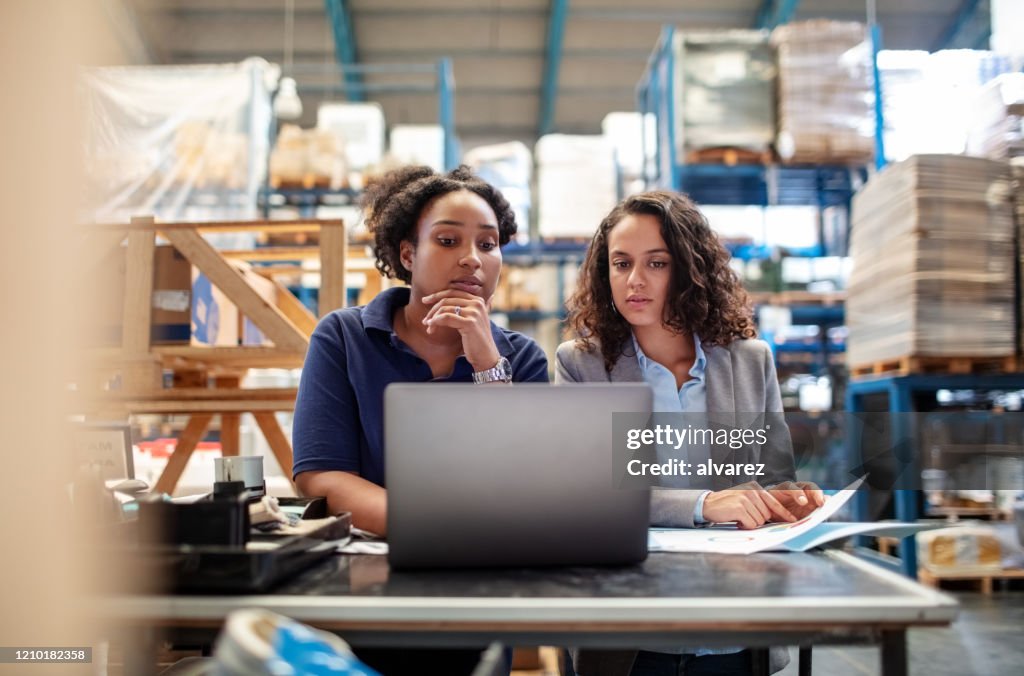 Trabajadora con supervisora que trabaja en portátil