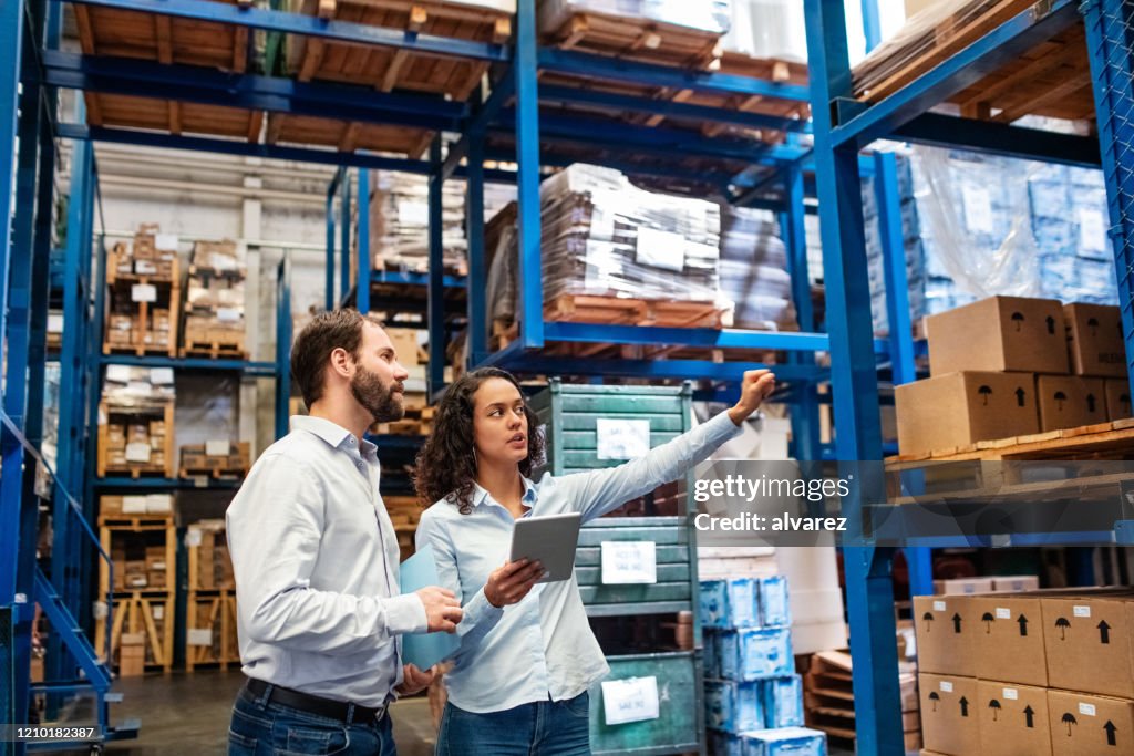 Gerente y supervisor tomando inventario en el almacén