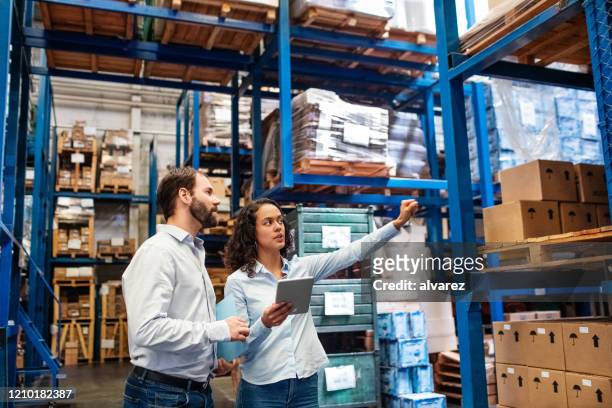 manager and supervisor taking inventory in warehouse - gerente imagens e fotografias de stock