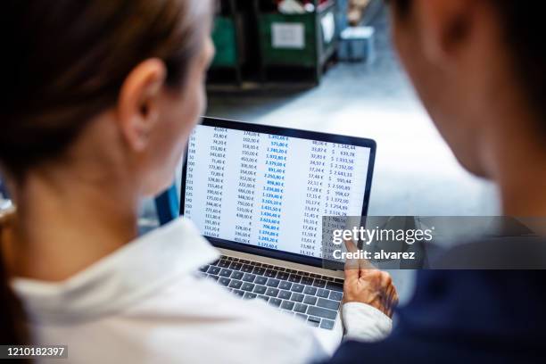 gerente de almacén y trabajador verificando el stock en el sistema - working behind laptop fotografías e imágenes de stock