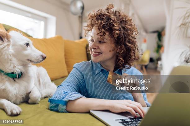 cute girl enjoying at home with her dog and shopping online - retail loyalty stock pictures, royalty-free photos & images