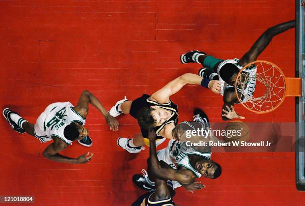 Overhead shot showing Pacers center Rik Smitts, in dark uniform, rebounding in the paint while surrounded by a trio of Boston Celtics, left to right,...