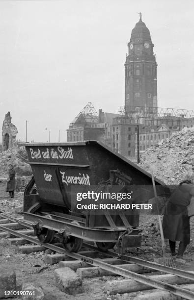 Photo dated 1945 showing residents and emergency personnel cleaning up rubble in front of the "New City Hall" building in the east German city of...