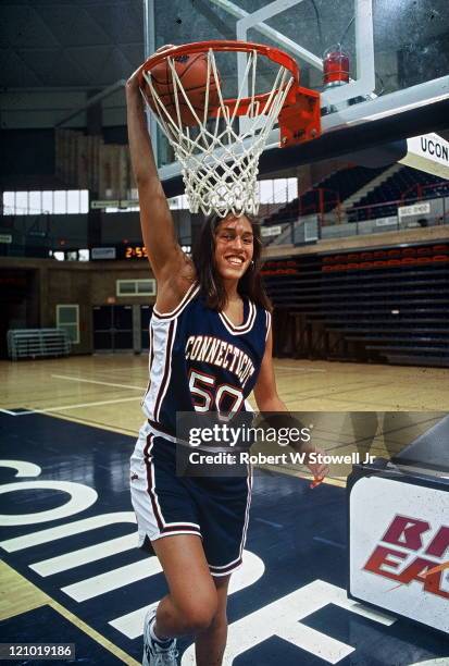 University of Connecticut's Rebecca Lobo, starting center for the UConn Huskies basketball team, brings the hoop down to her size, while posing in...