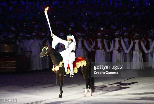 The torchbear makes his way to light the flame during the Opening Ceremony of the 15th Asian Games Doha 2006 at the Khalifa stadium in Doha, Qatar on...