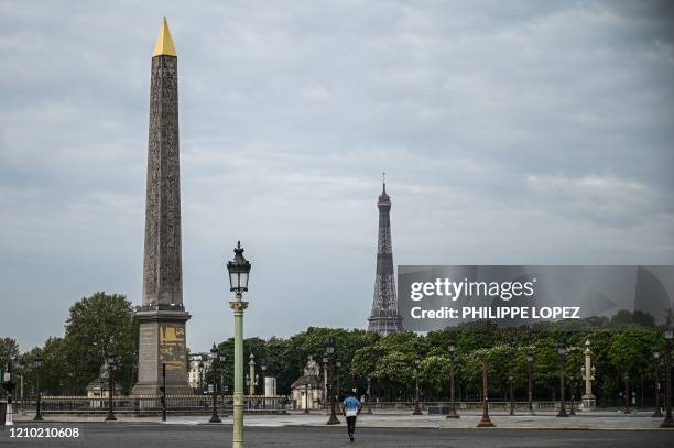 Man runs past the obelisk on the empty place of the Concorde in Paris on April 17, 2020 on the 32th day of a lockdown in France aimed at curbing the...