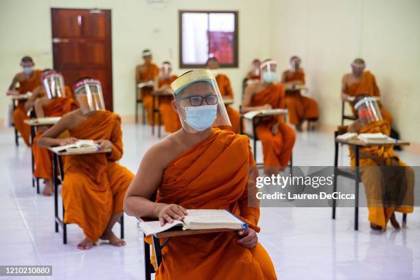 Thai Monks wear face maks and face shields to protect themselves from the coronavirus during their Pali language course at Wat Molilokkayaramon April...