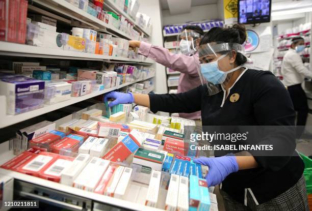 Pharmacy assistant inside a Boots store prepares medicines for Bikeworks cycling instructor Jelil Adebiyi to deliver to vulnerable people, as part of...