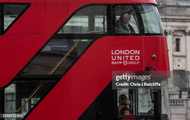 Bus driver wears a face mask whilst driving past Trafalgar Square on April 17, 2020 in London, United Kingsom. In a press conference on Thursday,...