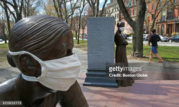 From left, statues of Lucy Stone and Abigail Adams are heeding the advice of Mayor Walsh and the CDC by wearing face masks on Commonwealth Avenue...
