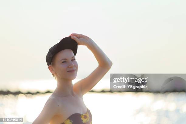 caucasian woman in swimsuit posing at seaside at sunset. - japanese swimsuit models stock pictures, royalty-free photos & images