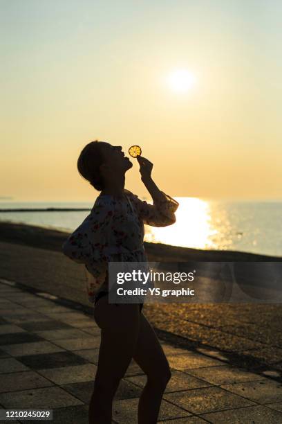 caucasian woman in swimsuit posing at seaside at sunset. - japanese swimsuit models stock pictures, royalty-free photos & images