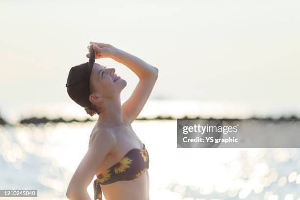 caucasian woman in swimsuit posing at seaside at sunset. - japanese swimsuit models stock pictures, royalty-free photos & images