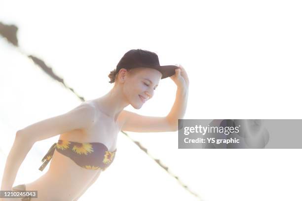 caucasian woman in swimsuit posing at seaside at sunset. - japanese swimsuit models stock pictures, royalty-free photos & images