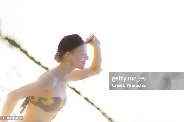 caucasian woman in swimsuit posing at seaside at sunset. - japanese swimsuit models stock pictures, royalty-free photos & images