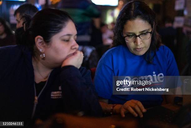 Campaign volunteers for Democratic presidential candidate Sen. Bernie Sanders look at election headlines on at an election watch party Super Tuesday...