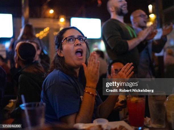 Campaign volunteers for Democratic presidential candidate Sen. Bernie Sanders cheer as they look at television election results at an election watch...