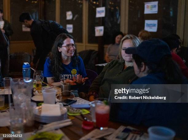 Campaign volunteers for Democratic presidential candidate Sen. Bernie Sanders discuss election headlines at an election watch party on Super Tuesday...