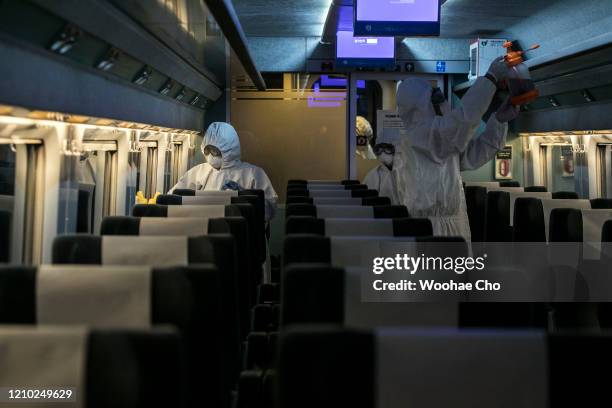 Disinfection workers, in protective gear, disinfect a passenger car of the KTX, a Korean express train, against the coronavirus on March 04, 2020 in...