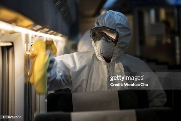 Disinfection worker, in protective gear, disinfects a passenger car of the KTX, a Korean express train, against the coronavirus on March 04, 2020 in...