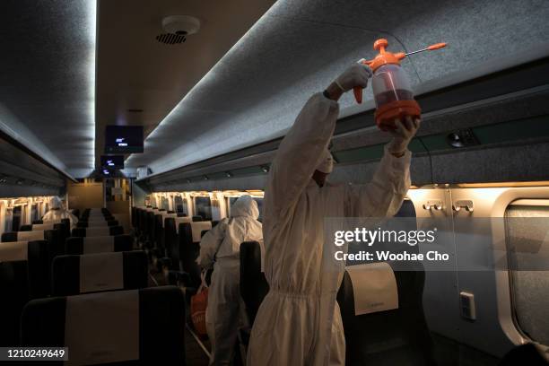 Disinfection workers, in protective gear, disinfect a passenger car of the KTX, a Korean express train, against the coronavirus on March 04, 2020 in...