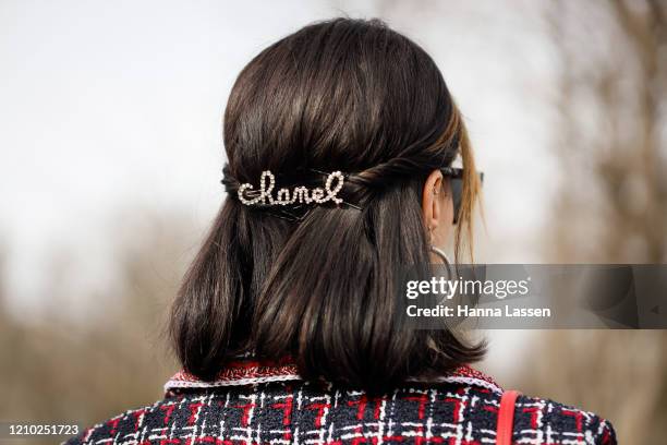 Brittany Xavier wearing Chanel headpiece, red and black tweed dress, red Chanel bag and white shoes outside Paris Fashion Week Womenswear Fall/Winter...