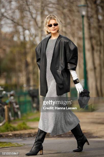Kate Tik wearing Chanel black oversized leather jacket, grey maxi dress, chanel bag, white gloves, bangle and black boots outside Paris Fashion Week...